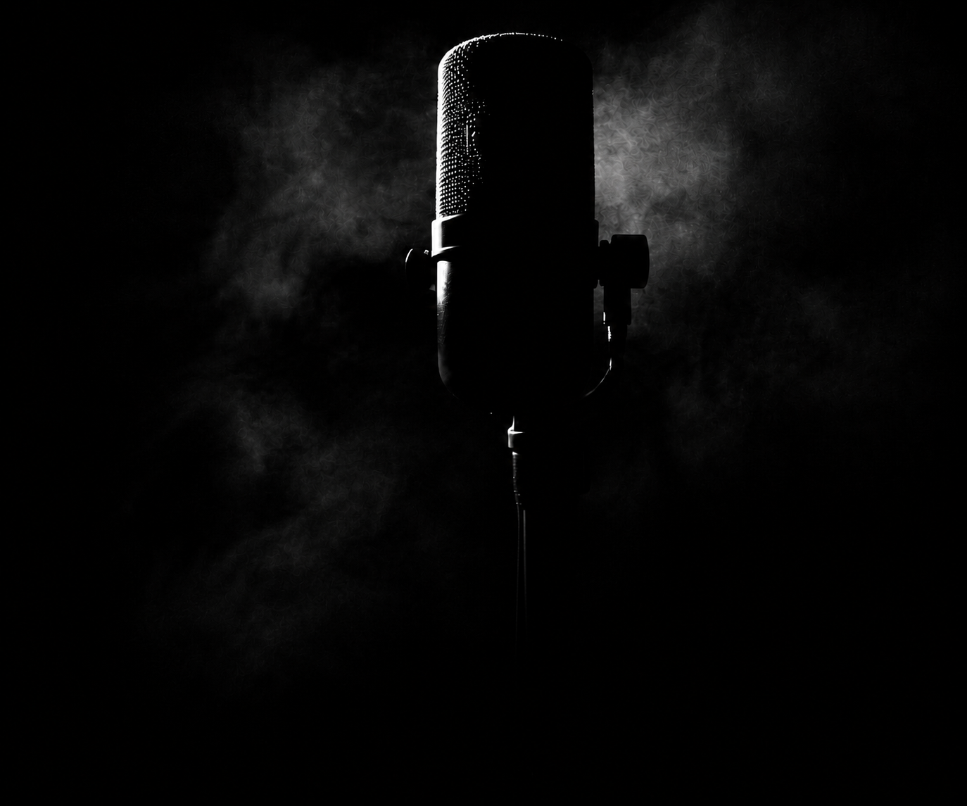Professional vintage microphone in a dark room with dramatic smoke backlighting